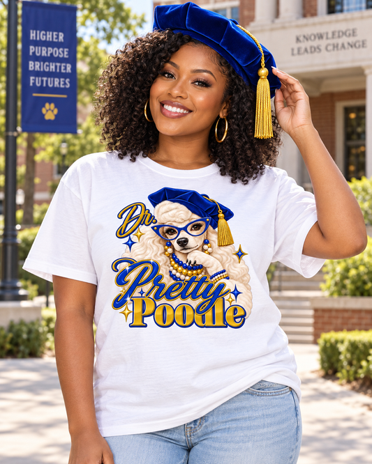 Black woman wearing Dr. Pretty Poodle white shirt and royal blue doctoral tam on a university campus