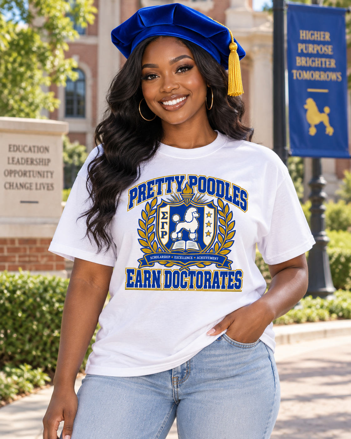 Black woman wearing Pretty Poodles Earn Doctorates white shirt and royal blue doctoral tam on a university campus